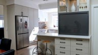 Kitchen with fridge and barstools