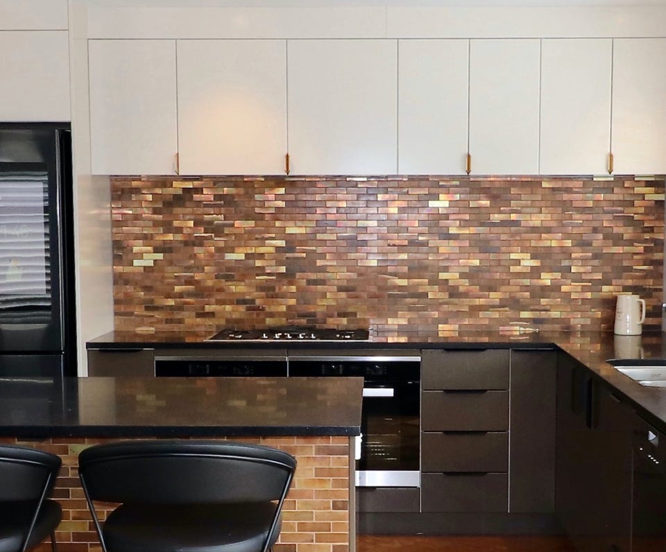 Studio 28 Interio Design Wellington Zealand. Creating wow interiors that are easy on the eye. New build kitchen with light cabinets above and chocolate below. Brass tile spalsh back and black leather bar stools with curved back.